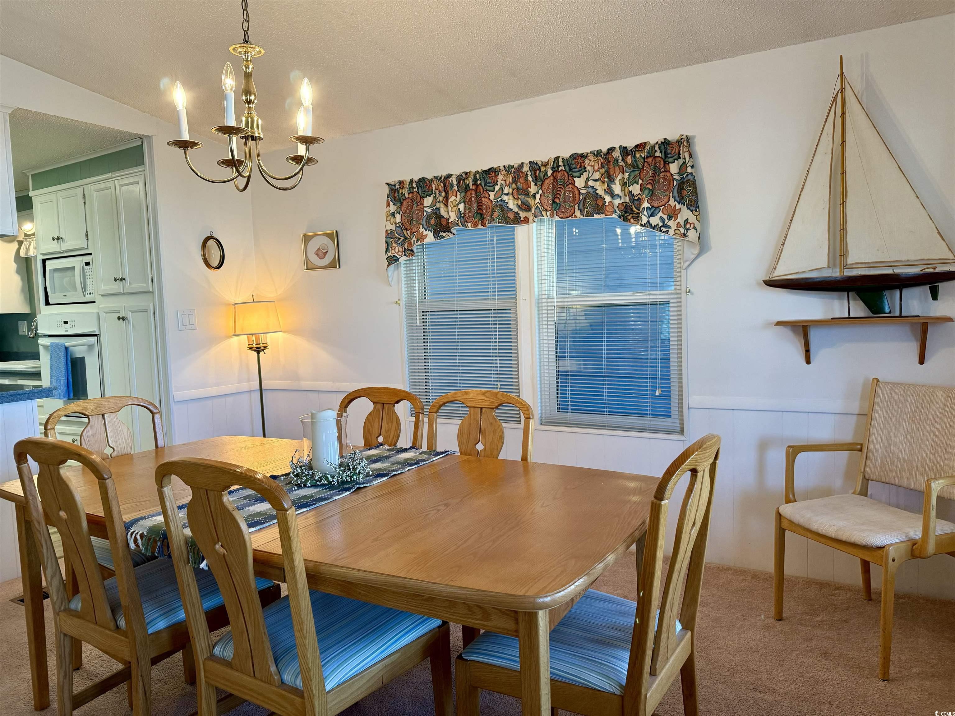 Carpeted dining space with a textured ceiling and