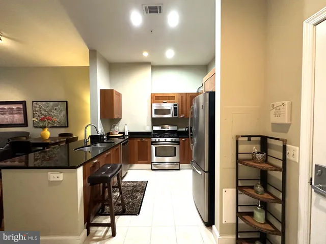 a kitchen with stainless steel appliances a refrigerator and a stove top oven