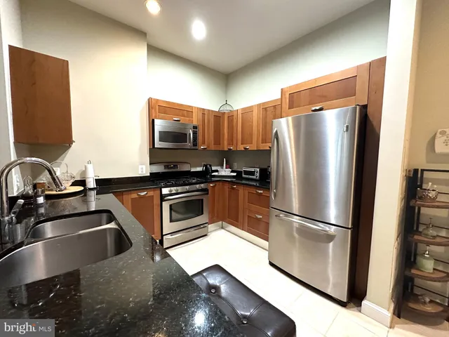 a kitchen with stainless steel appliances granite countertop a refrigerator and a sink