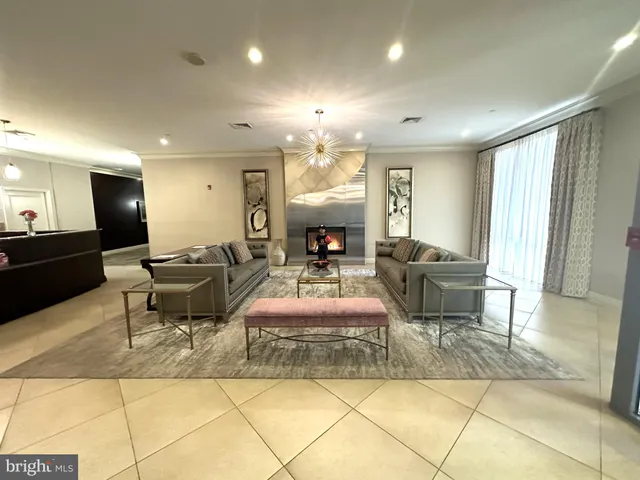 a living room with furniture a dining table and a chandelier