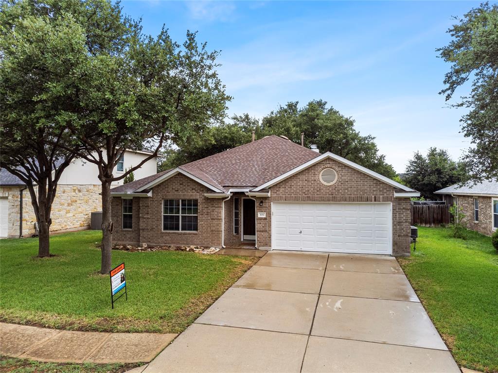 Ranch-style home featuring an attached garage, brick siding, concrete driveway, and a shingled roof