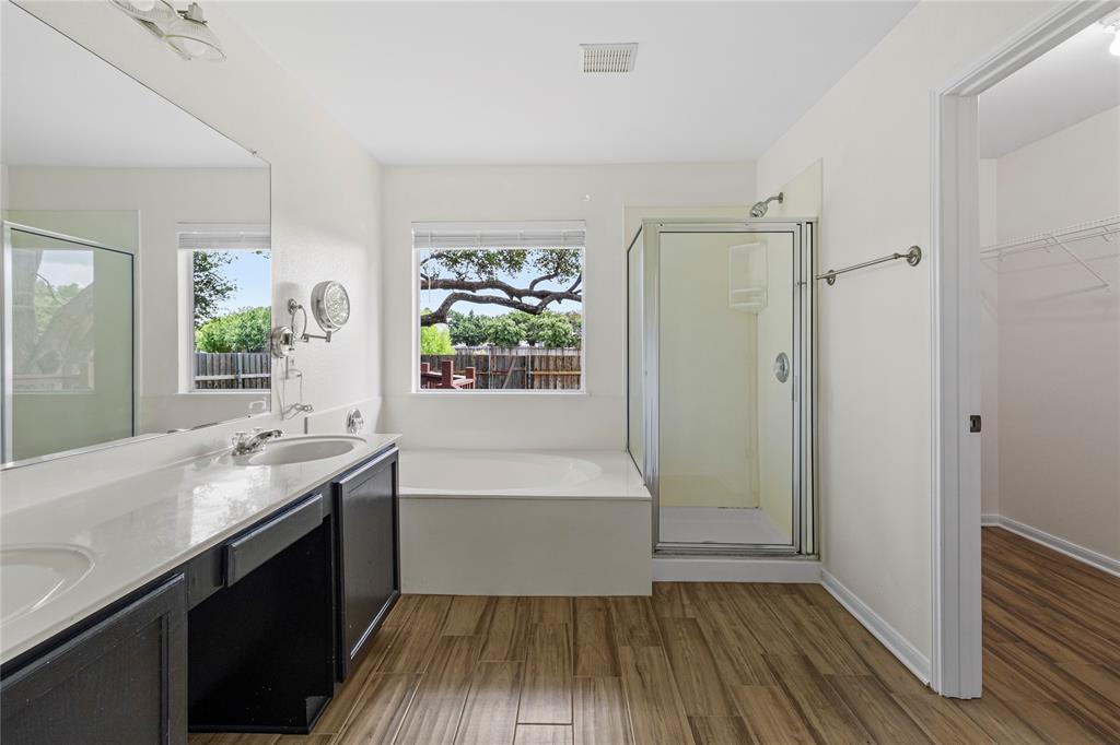 1011 St Helena Drive Leander, TX 78641 - Photo 7 of 11 Full bathroom with dark wood-style floors, a spacious closet, a stall shower, and a garden tub