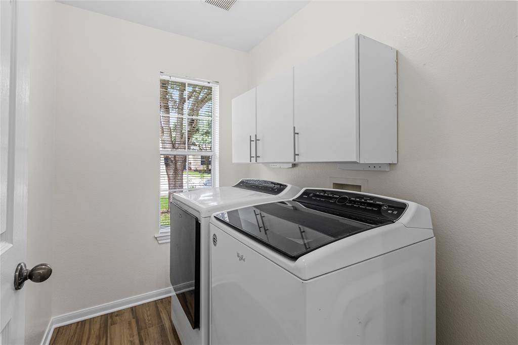 1011 St Helena Drive Leander, TX 78641 - Photo 8 of 11 Washroom featuring dark wood-style flooring, cabinet space, and washer and dryer
