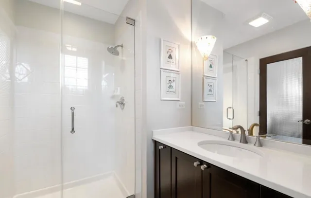 a bathroom with a granite countertop sink a shower and a mirror