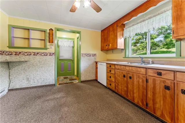 a view of a kitchen with a sink and dishwasher next to a window