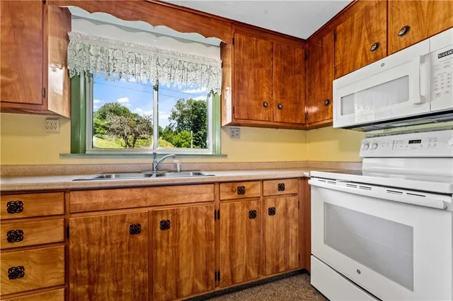 a kitchen with granite countertop white cabinets stainless steel appliances and a sink
