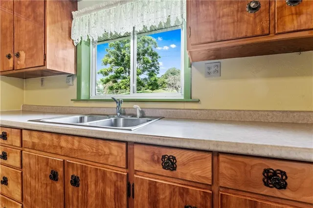 a sink with a window and cabinets
