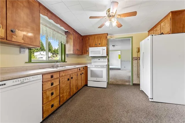 a kitchen with white cabinets and white stainless steel appliances