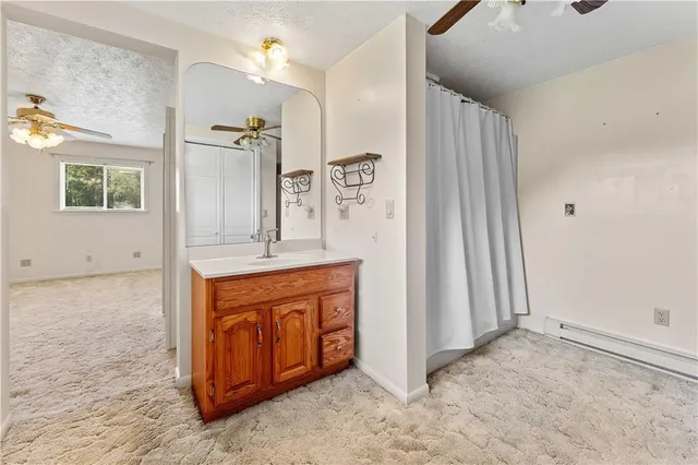 an empty room with a chandelier fan and closet