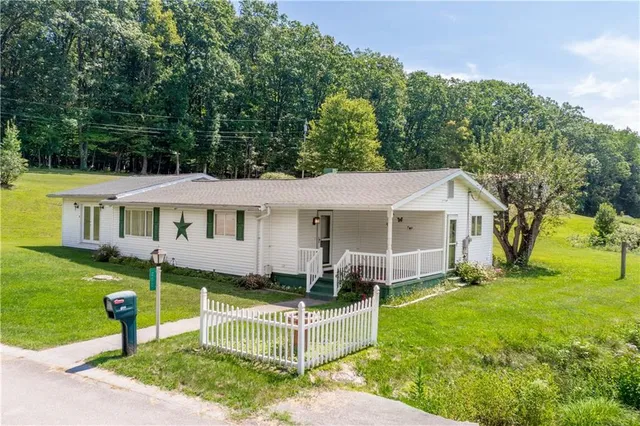 a view of a house with a yard and sitting area