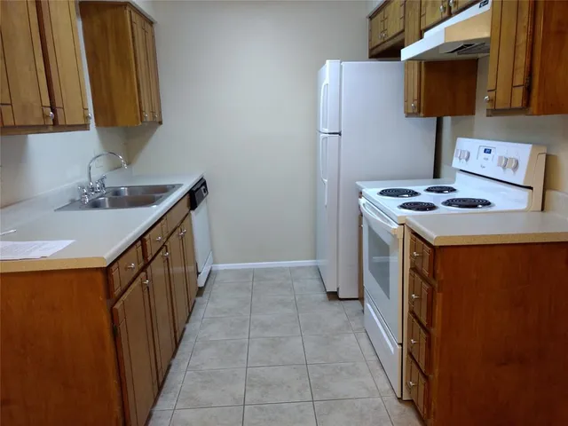 a utility room with a sink a stove and a microwave