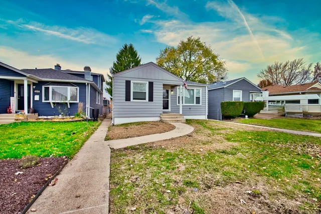 a front view of a house with a yard and potted plants