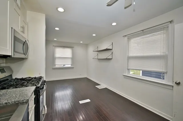 a view of a kitchen with a stove wooden cabinets and a refrigerator