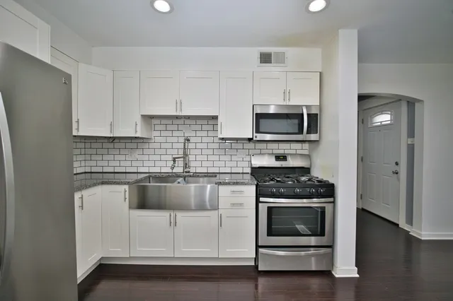 a kitchen with white cabinets and appliances