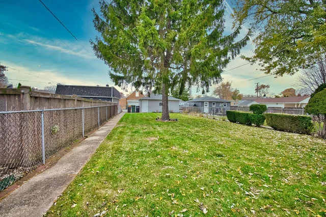 a view of a backyard with wooden fence