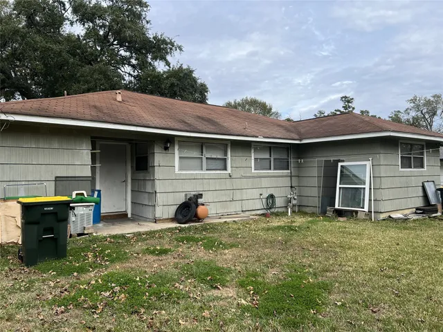 a view of a house with a yard and a large tree