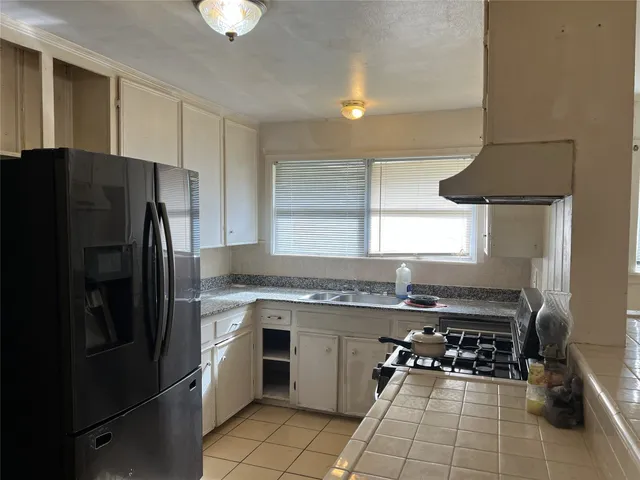 a kitchen with a sink a refrigerator and a stove