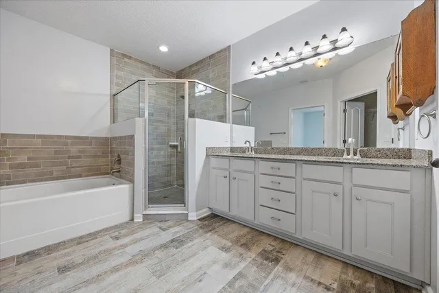 a spacious bathroom with a granite countertop sink mirror and bathtub