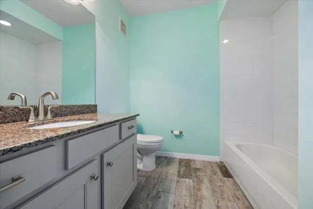 a bathroom with a granite countertop sink toilet and shower