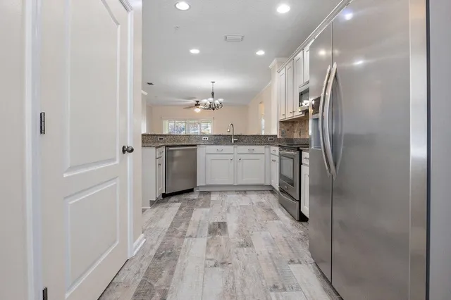 a kitchen with stainless steel appliances granite countertop a refrigerator and a sink