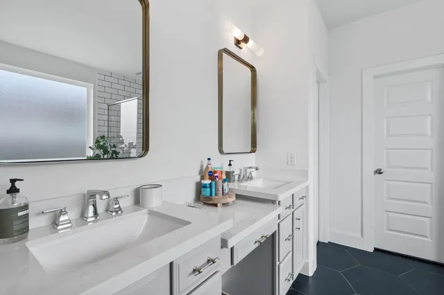 a bathroom with double vanity sink and a mirror