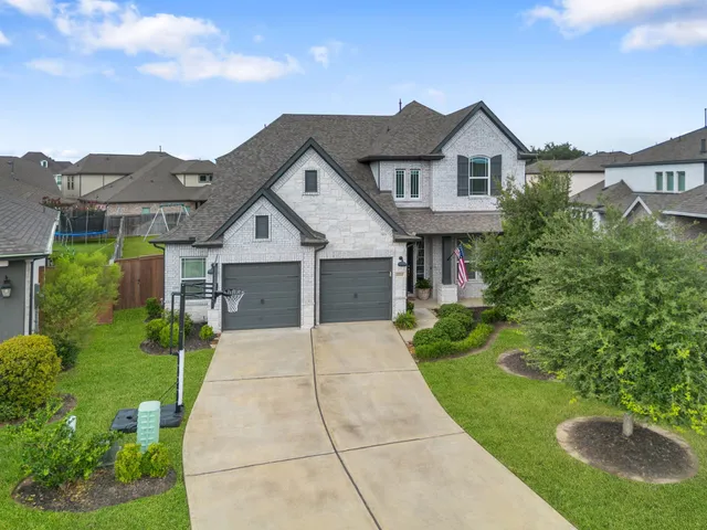 a view of a house with a yard and potted plants