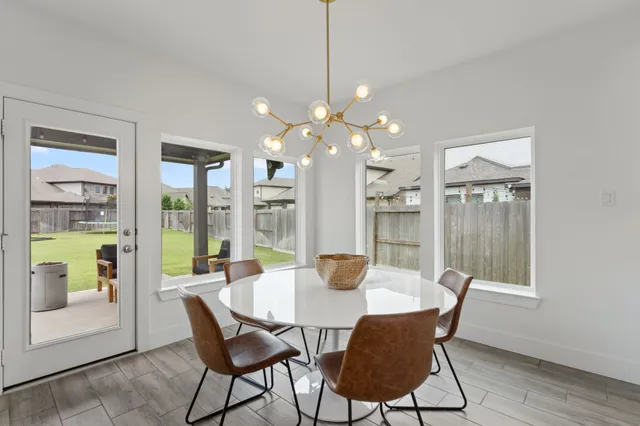 a dining room with furniture a chandelier and wooden floor