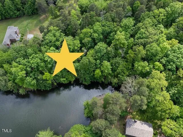 an aerial view of a house with a yard and lake view