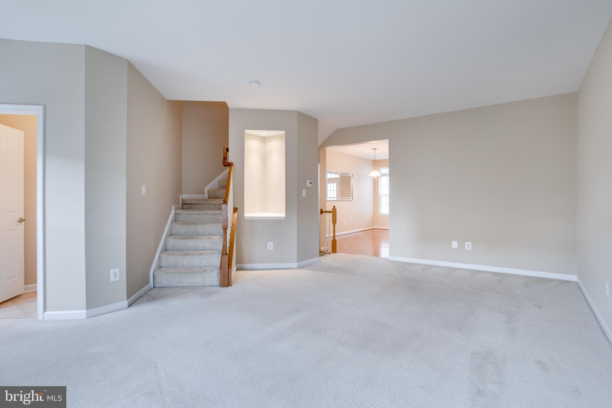 7012 Trek Way Gainesville, VA 20155 - Photo 14 of 33 a view of an empty room with wooden floor and stairs