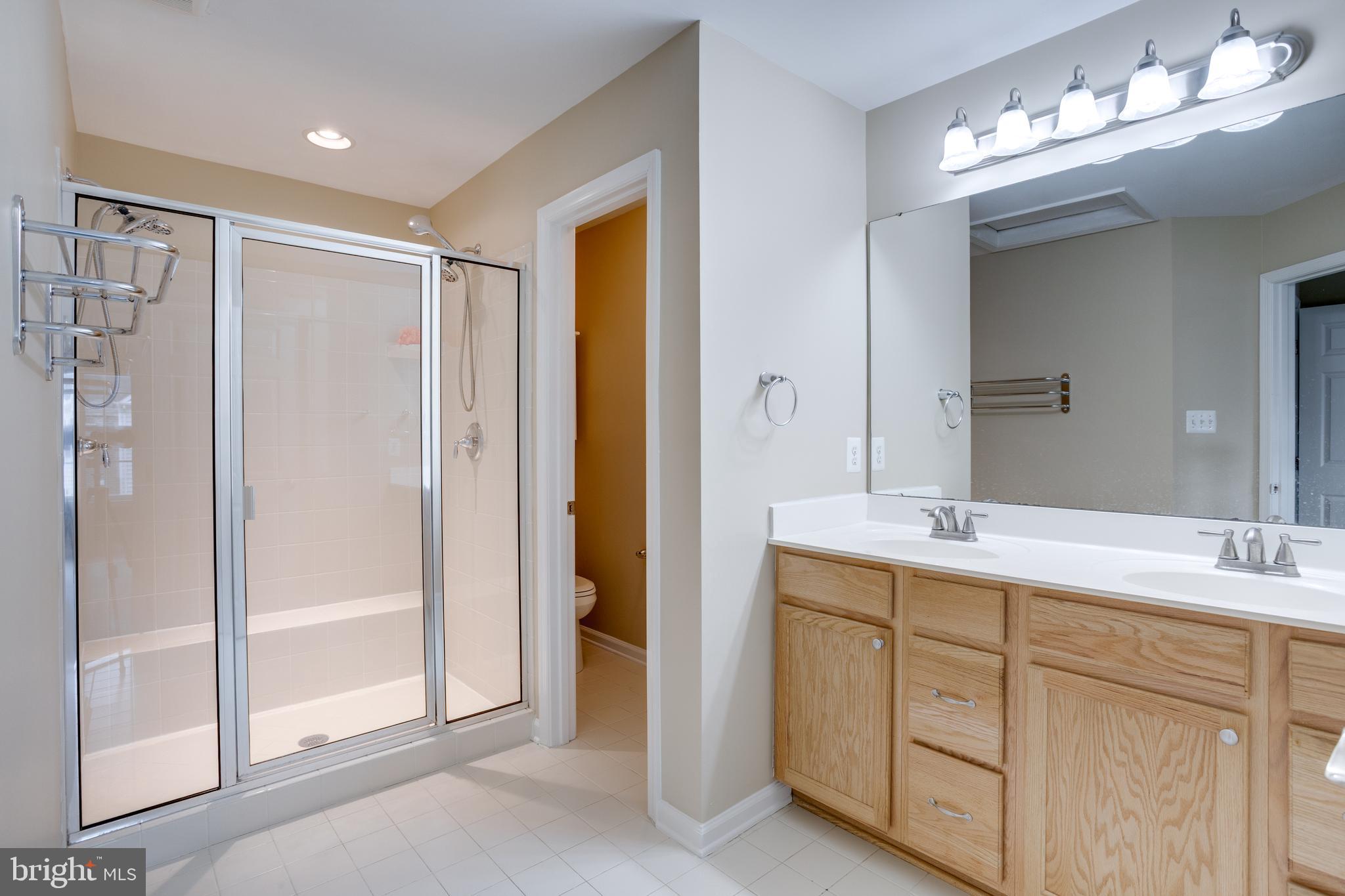 7012 Trek Way Gainesville, VA 20155 - Photo 19 of 33 a bathroom with a double vanity sink mirror and shower