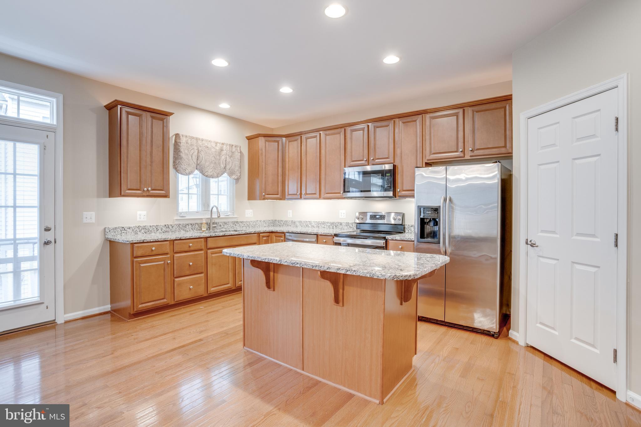 7012 Trek Way Gainesville, VA 20155 - Photo 3 of 33 a kitchen with kitchen island granite countertop appliances cabinets and a sink