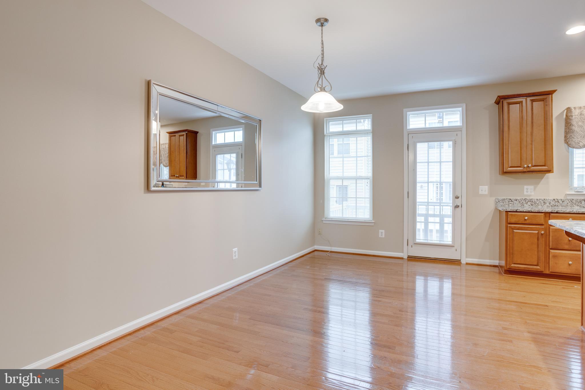 7012 Trek Way Gainesville, VA 20155 - Photo 9 of 33 a view of an empty room with a window and wooden floor