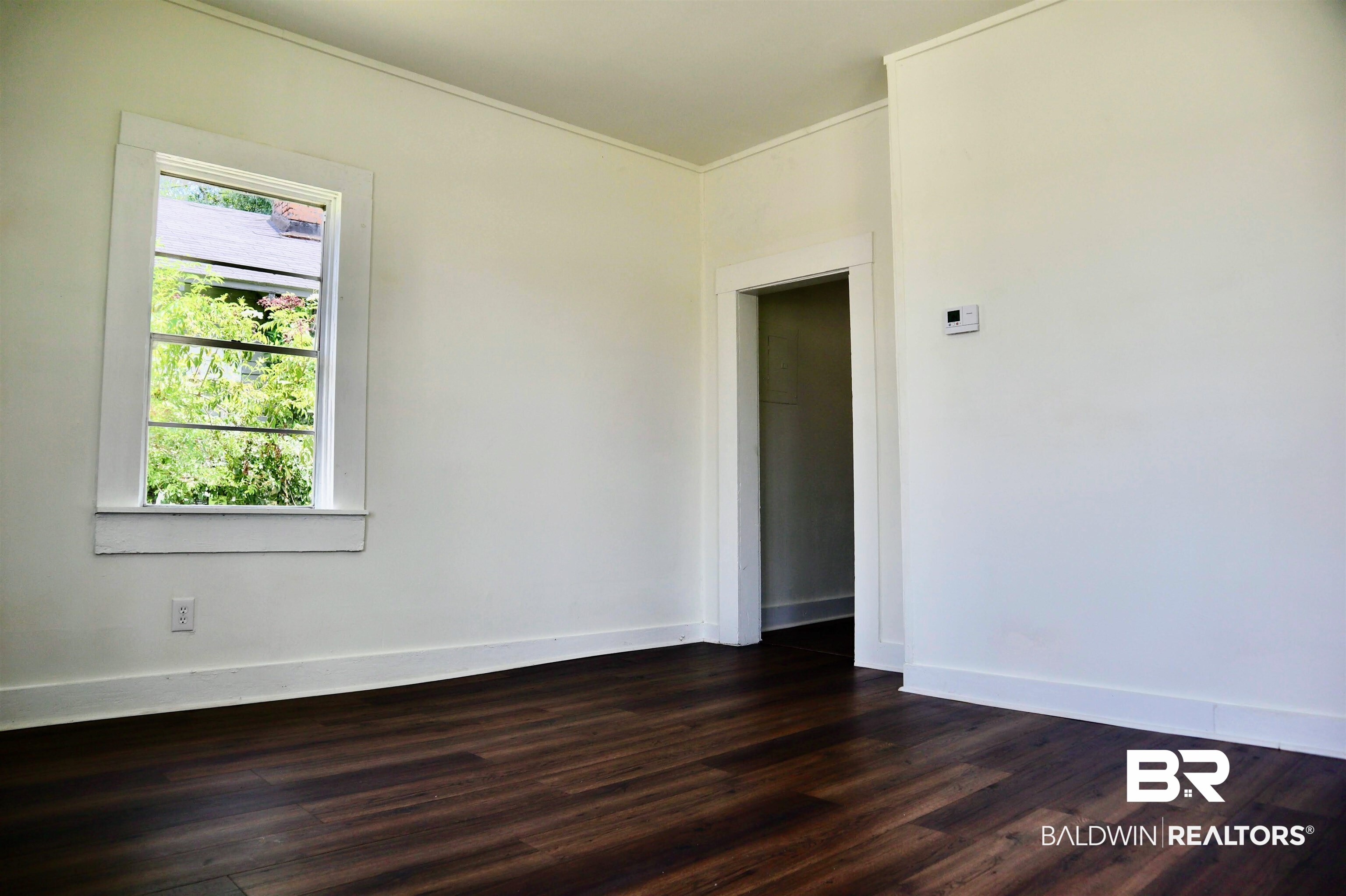 1009 Baltimore Street Mobile, AL 36605 - Photo 7 of 17 Empty room featuring dark wood-style floors and crown molding
