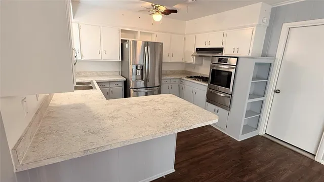 a kitchen with stainless steel appliances a refrigerator sink stove microwave and cabinets