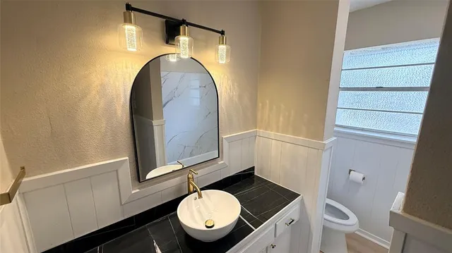 a bathroom with a toilet mirror and vanity
