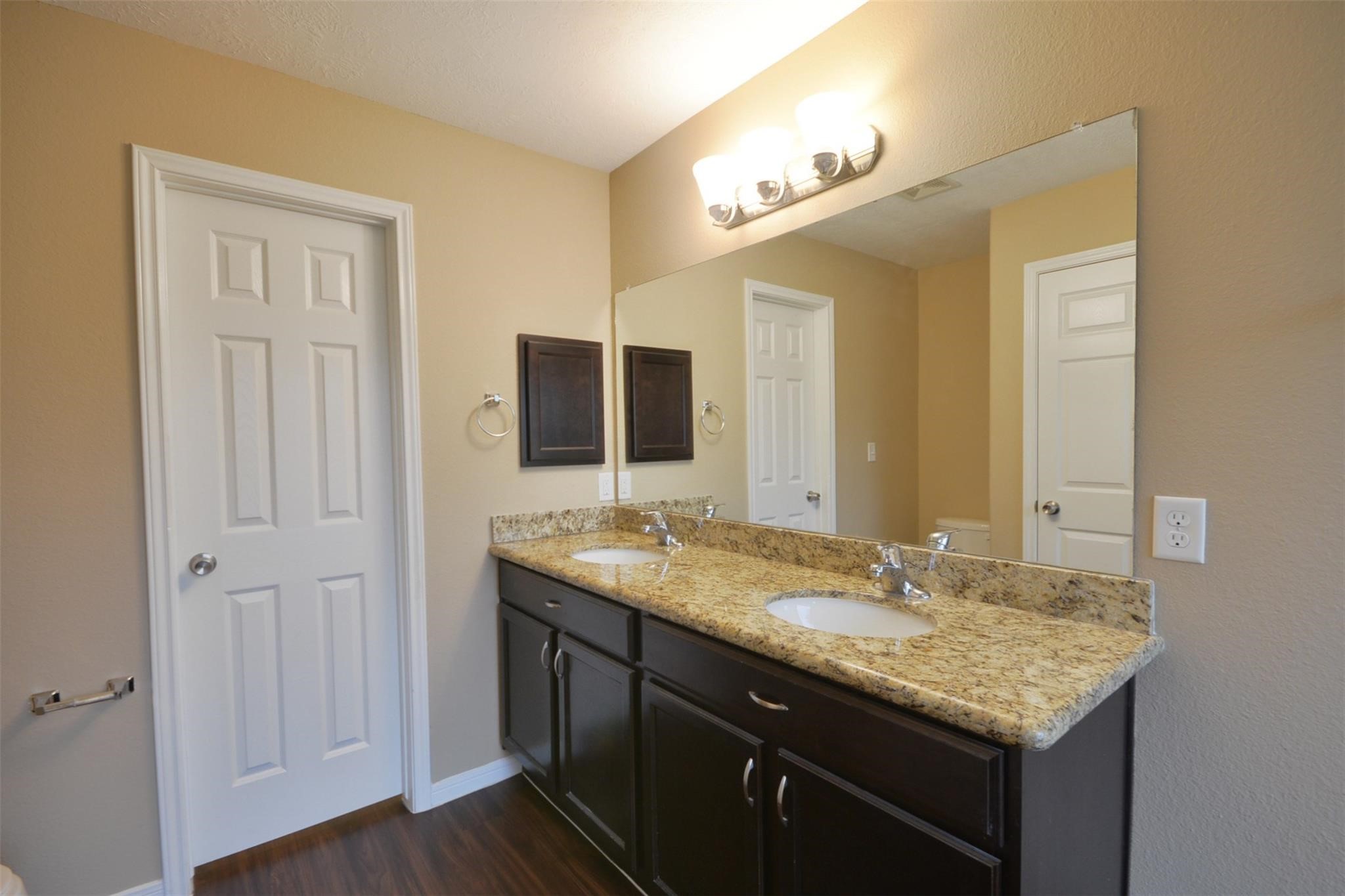 106 Eddy Street, Unit B Humble, TX 77338 - Photo 13 of 22 a bathroom with a granite countertop sink and a mirror