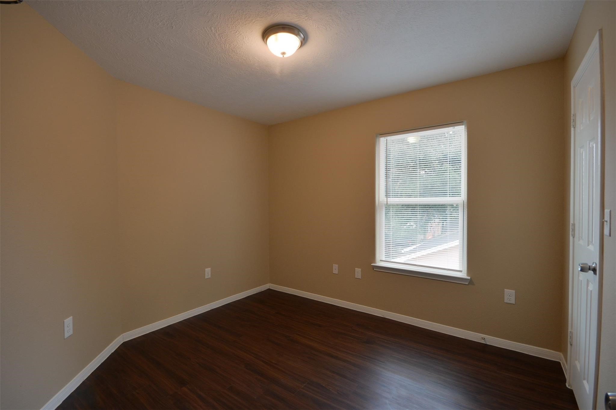 106 Eddy Street, Unit B Humble, TX 77338 - Photo 15 of 22 an empty room with wooden floor and windows
