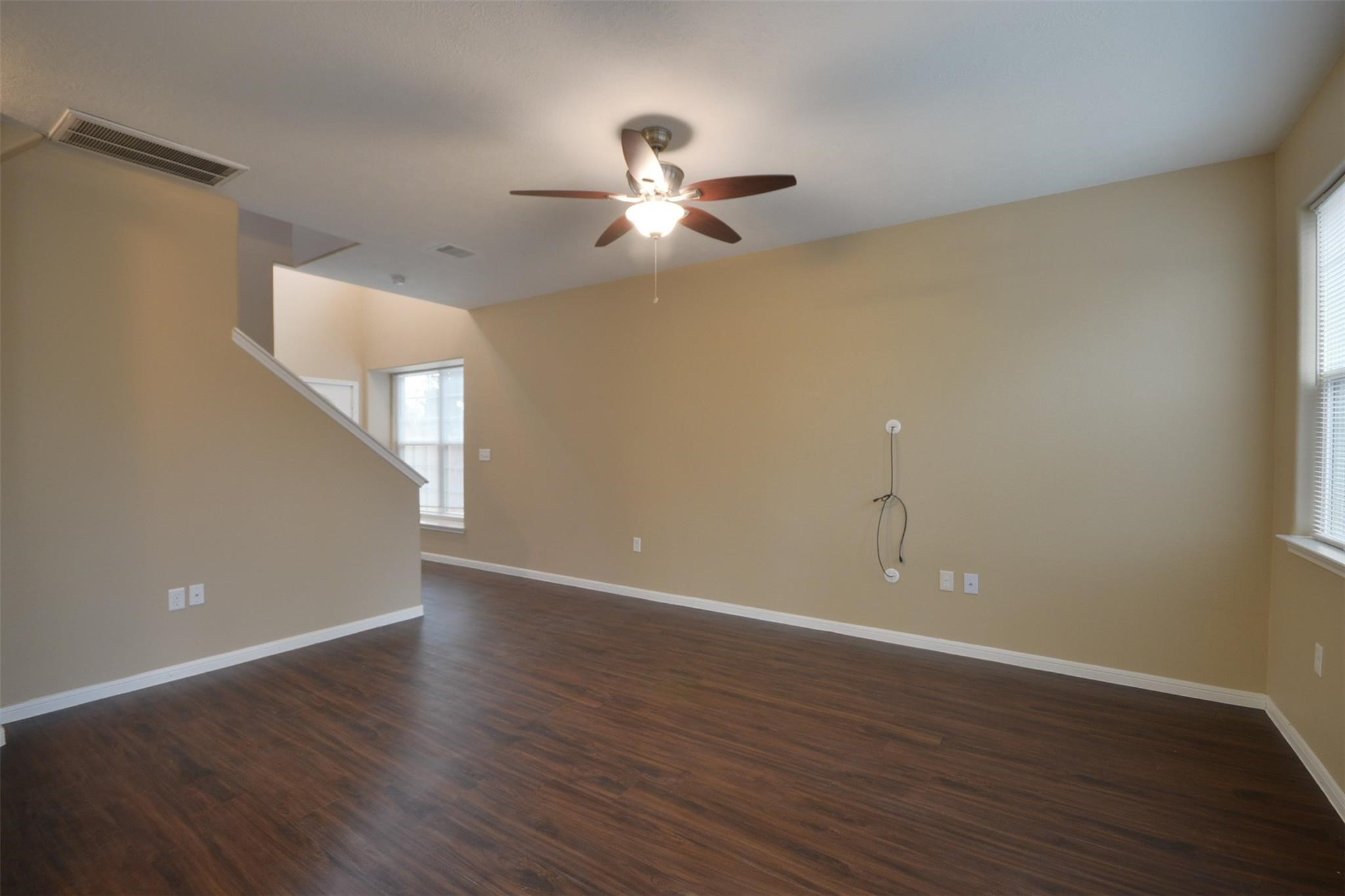 106 Eddy Street, Unit B Humble, TX 77338 - Photo 3 of 22 a view of an empty room with wooden floor and a ceiling fan