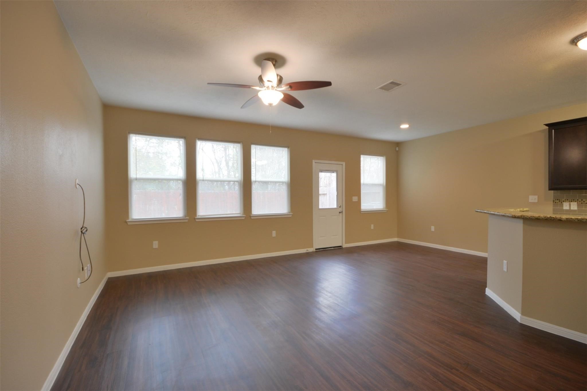 106 Eddy Street, Unit B Humble, TX 77338 - Photo 4 of 22 a view of an empty room with a window and wooden floor