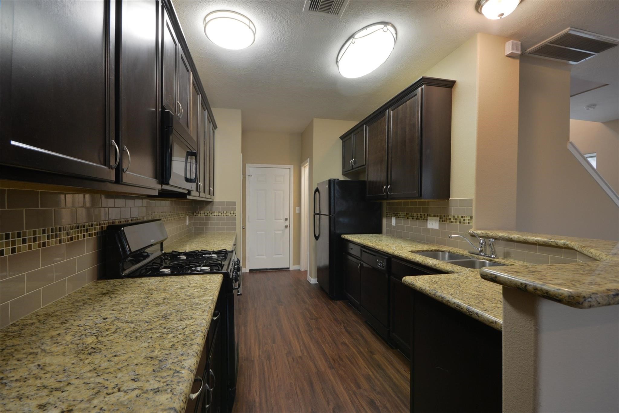 106 Eddy Street, Unit B Humble, TX 77338 - Photo 6 of 22 a kitchen with a sink stove and cabinets