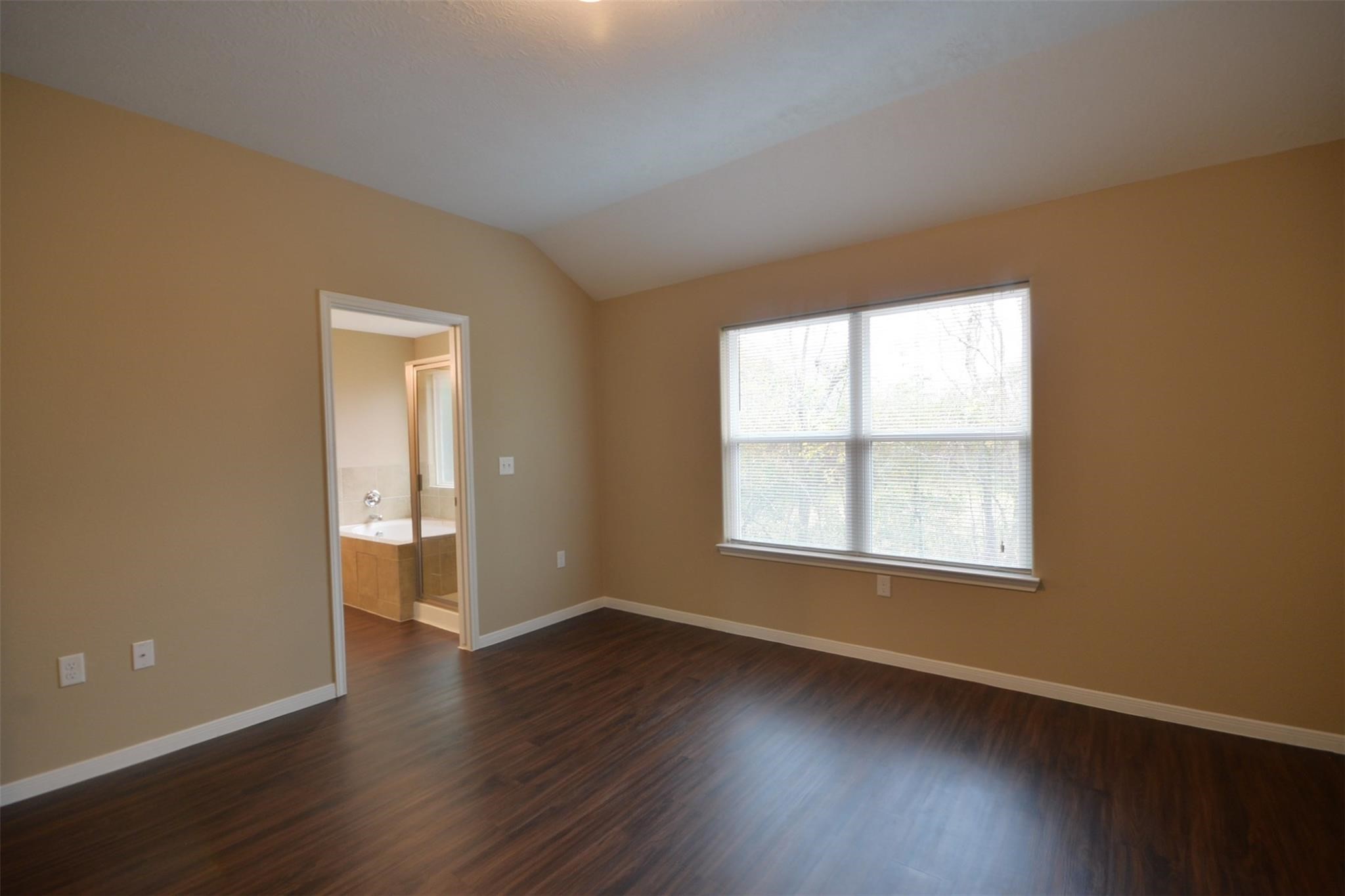 106 Eddy Street, Unit B Humble, TX 77338 - Photo 9 of 22 an empty room with wooden floor and windows