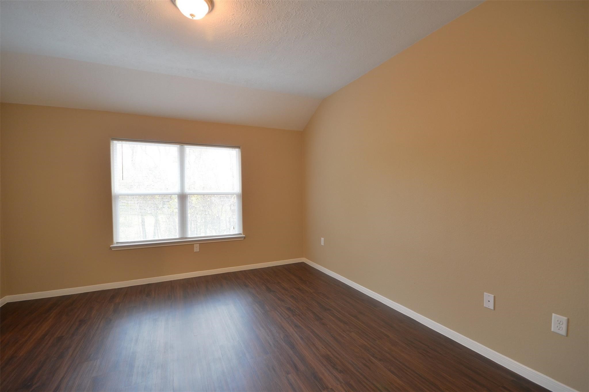 106 Eddy Street, Unit B Humble, TX 77338 - Photo 10 of 22 an empty room with wooden floor and windows