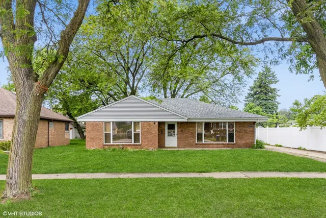 a front view of a house with a garden and yard