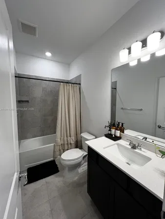 a bathroom with a sink a toilet a mirror and shower