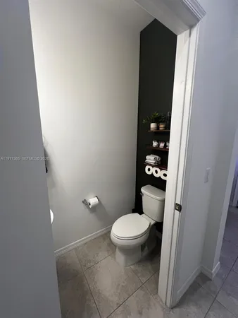 a bathroom with a granite countertop toilet and a shower