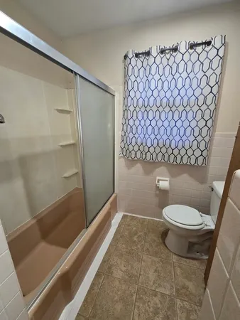 a bathroom with a toilet and a shower