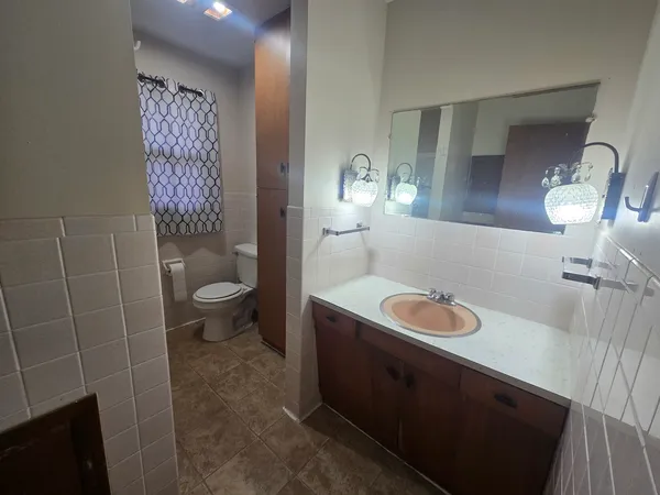 a bathroom with a sink a toilet and a mirror
