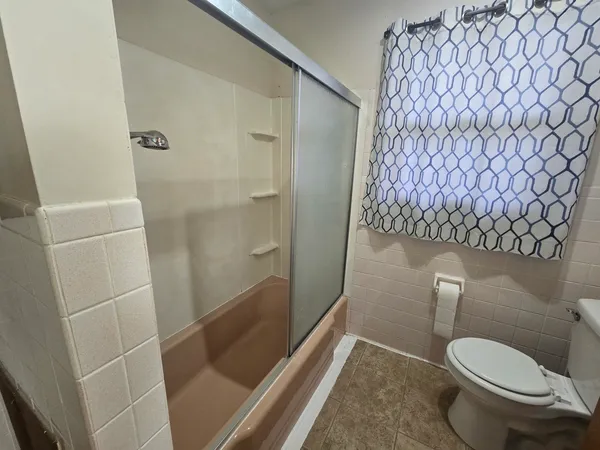 a bathroom with a toilet and shower