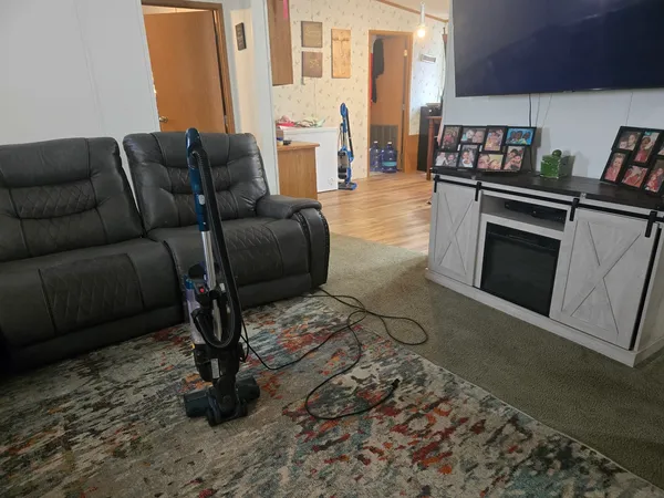 a living room with furniture a rug and a stove