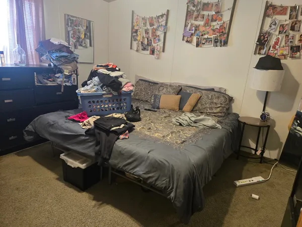 a bed sitting in a bedroom next to a window